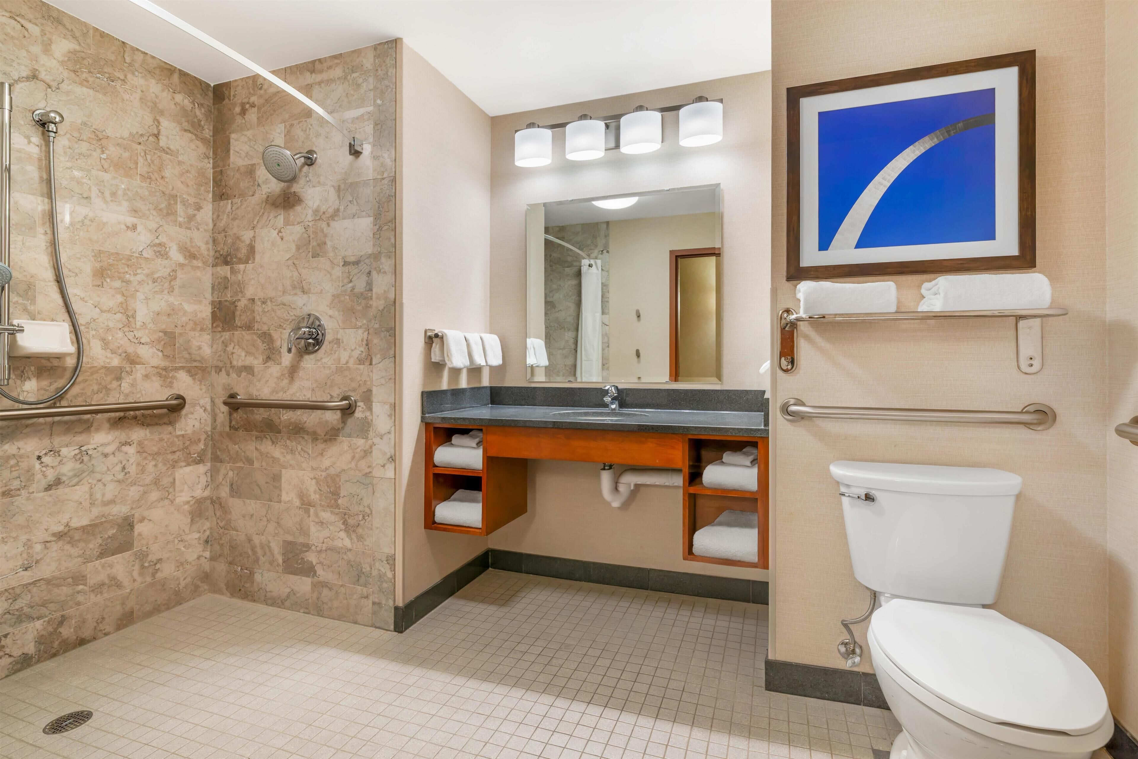 Un baño moderno con ducha, tocador e inodoro.