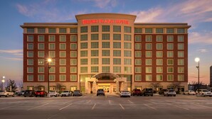 Ein Drury Plaza Hotel mit großem Parkplatz und mehreren parkenden Autos vor der Fassade.