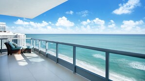 Ein Balkon mit Blick auf das Meer und ein Gebäude im Hintergrund.