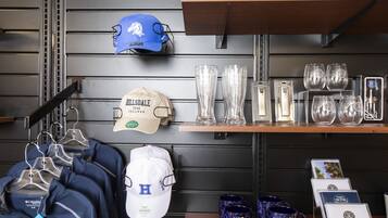 Exhibición de artículos de Hillsdale College, incluyendo gorras, camisetas y tazas.