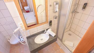 Ein Badezimmer mit Waschbecken, Spiegel, Toilette und Dusche.