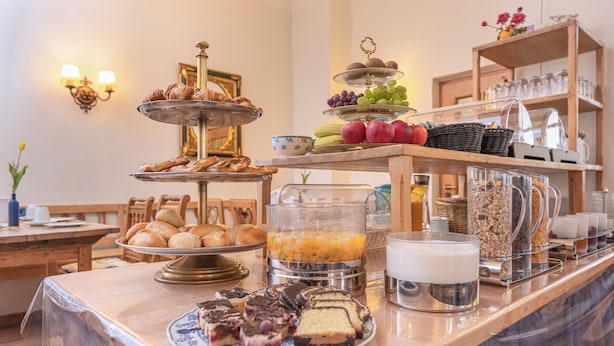 A breakfast buffet with various pastries, fruits, and beverages. - Eder  (Munich)