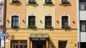 A yellow building with multiple windows and a sign that reads "HOTEL EDER". - Eder  (Munich)