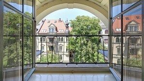 A balcony with a view of historic buildings and trees. - Hotel Uhland (Munich)