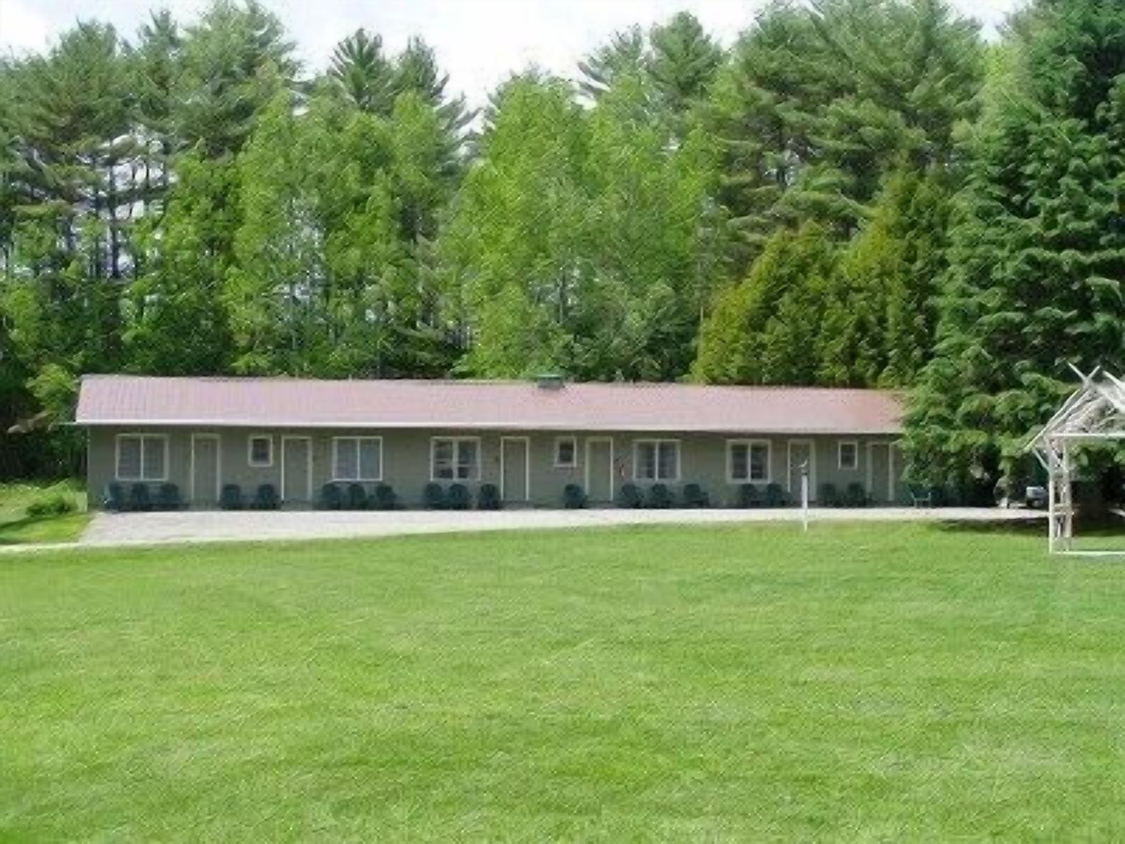 A single-story motel with a flat roof, a covered front porch, and a well-maintained lawn.