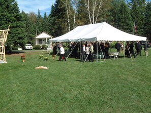 Evento al aire libre con carpas y gente reunida.