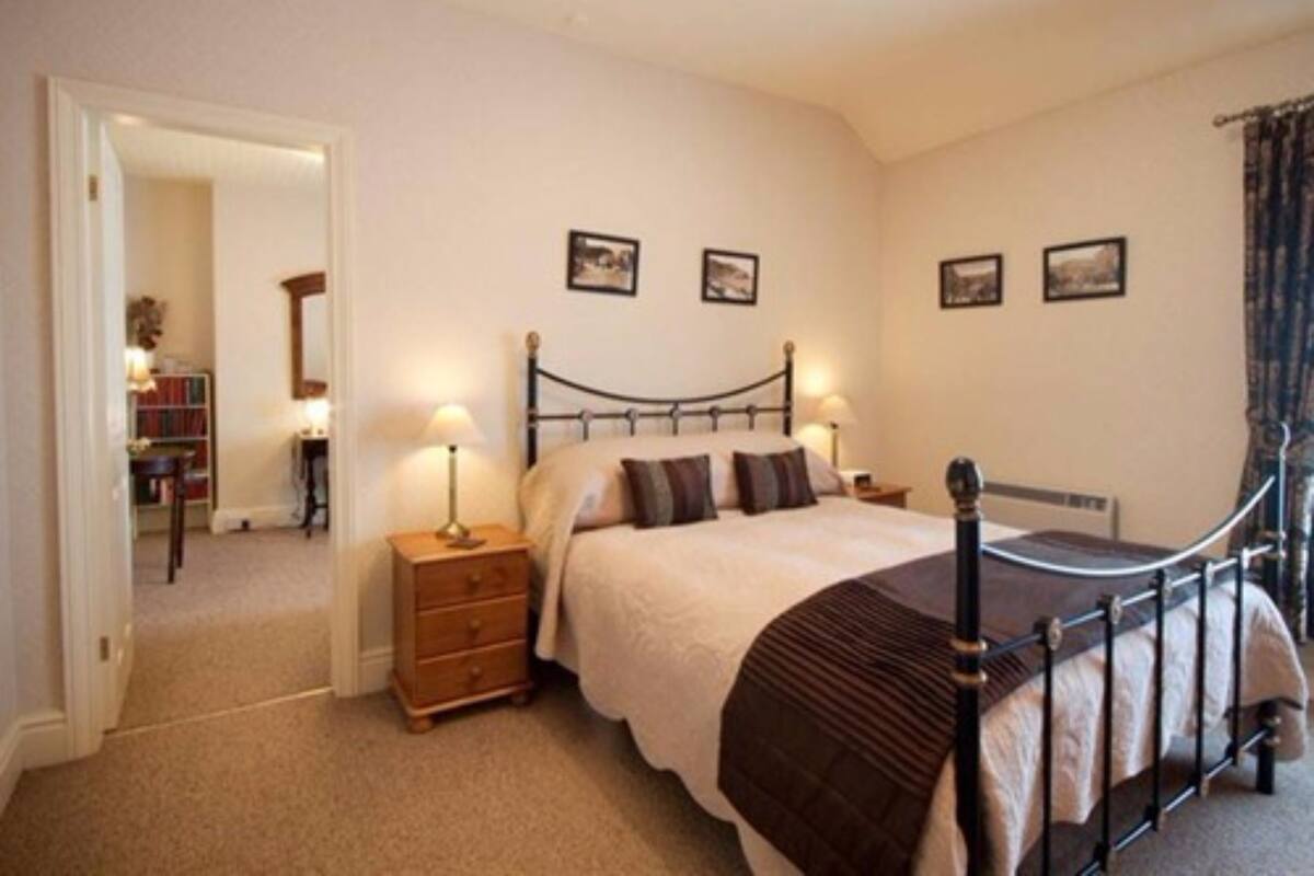 A bedroom with a bed, bedside tables, a dresser, and a bookshelf.