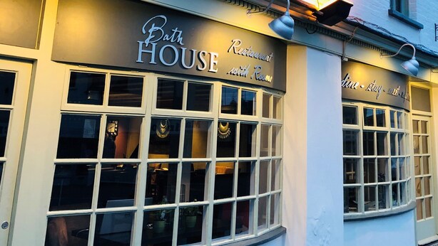 Un edificio con un letrero que dice "Bath House Restaurant with Rooms".