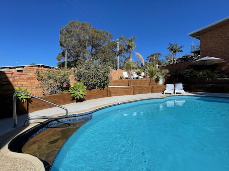 Outdoor pool, pool umbrellas, pool loungers. Ocean View Motor Inn