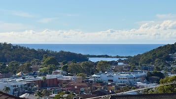A coastal town with buildings, a view of the sea, and a hilly landscape.