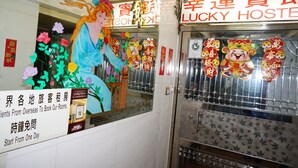 L’intérieur d’un hôtel, avec une enseigne indiquant « Lucky Hostie » et une affiche faisant la publicité de l’offre « Clients étrangers, réservez nos chambres ».