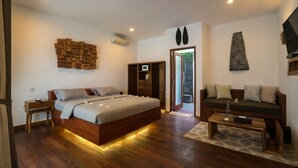 A modern bedroom with a wooden bed, a sofa, and a small table. - Villa Nero (Gili Trawangan)