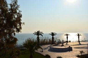 Un paseo marítimo con palmeras y una zona de estar circular.
