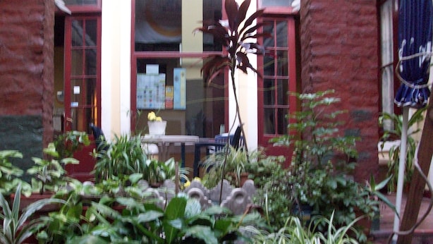A courtyard with potted plants and a table with chairs. - Santino Recoleta (Buenos Aires)