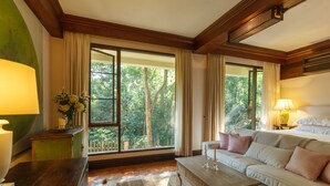 A room with a large window, a sofa, a coffee table, and a lamp. - Vanā Som (Mae Rim)