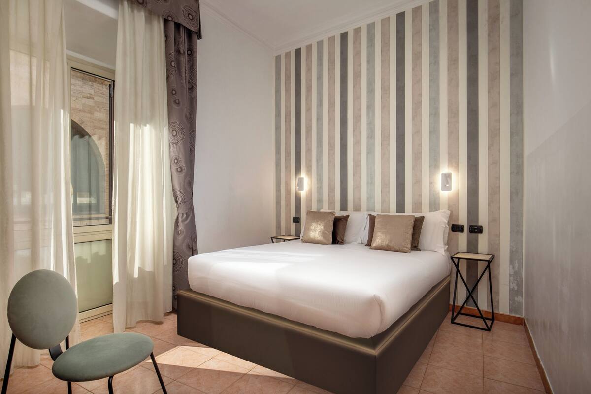 A modern bedroom with a large bed, two bedside tables, and a chair.