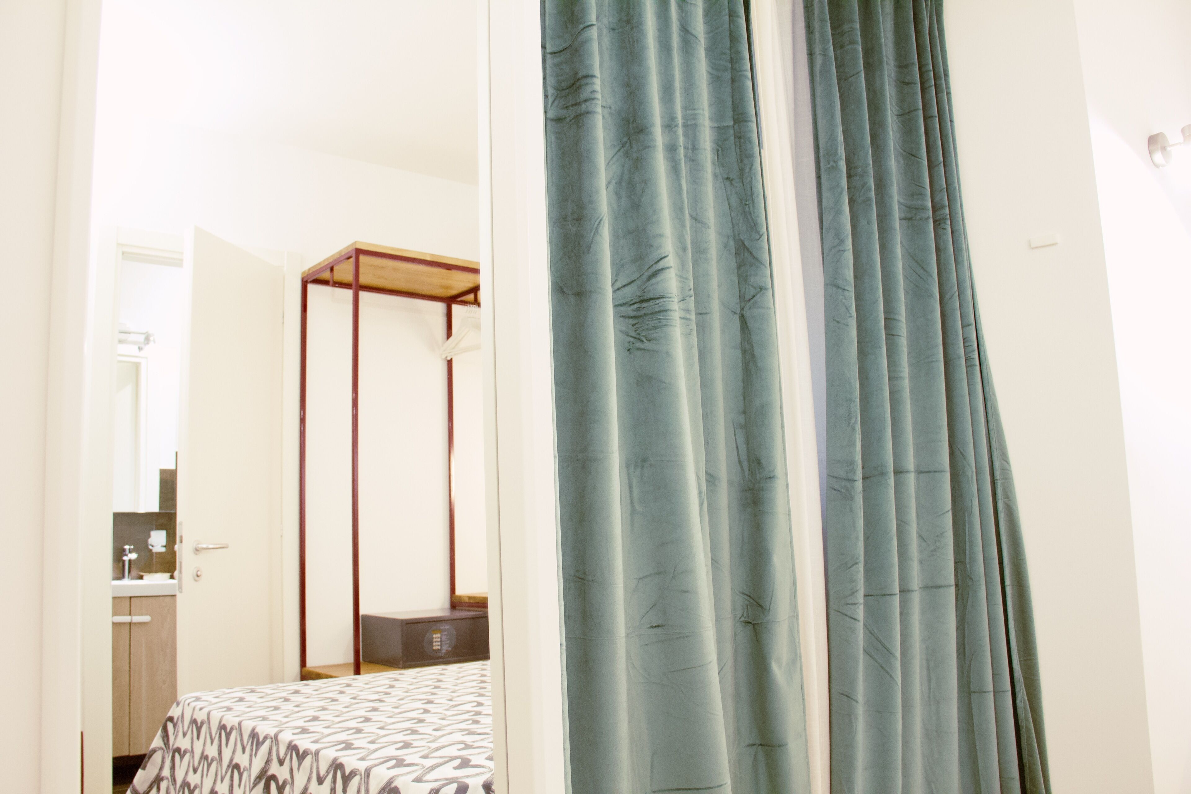A bedroom with a four-poster bed, a bedside table, and a wardrobe.