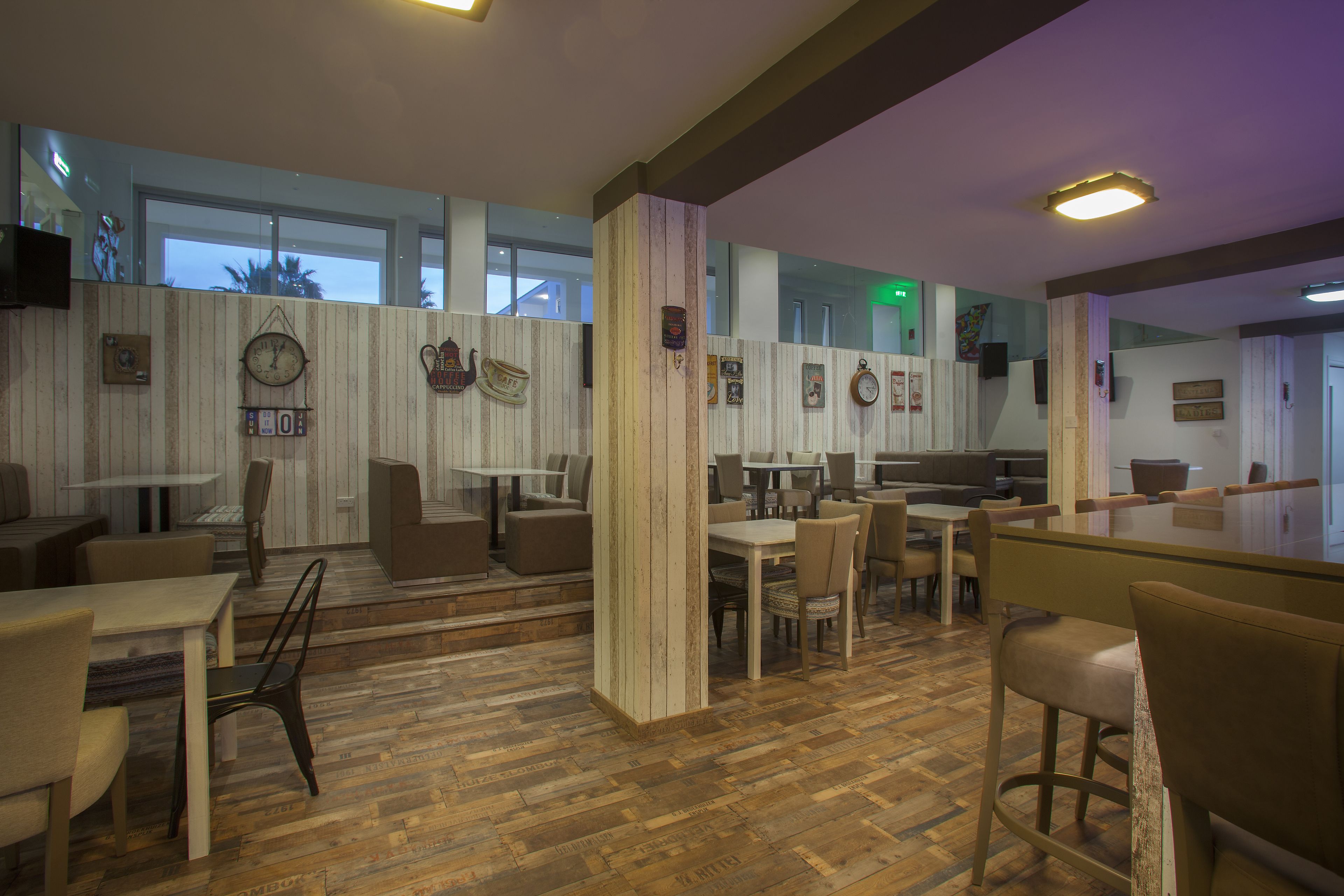 Un intérieur moderne avec un plancher en bois, plusieurs coins salon et un bar.
