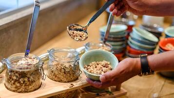 A breakfast buffet with various food options in glass jars and bowls.