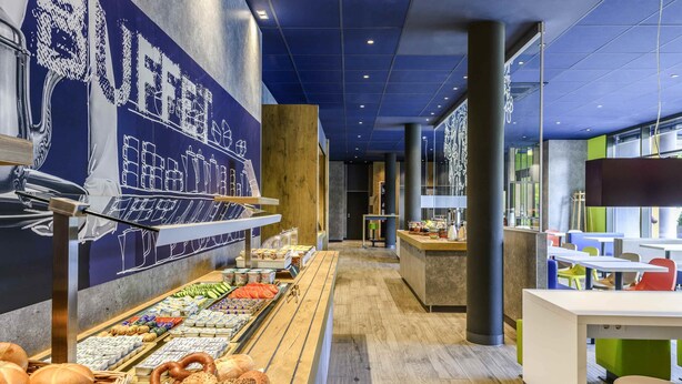 A buffet area with various food items, a seating area with tables and chairs, and a counter with a display of food.