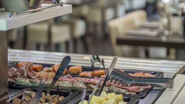 Un bufé con diversos alimentos y utensilios.