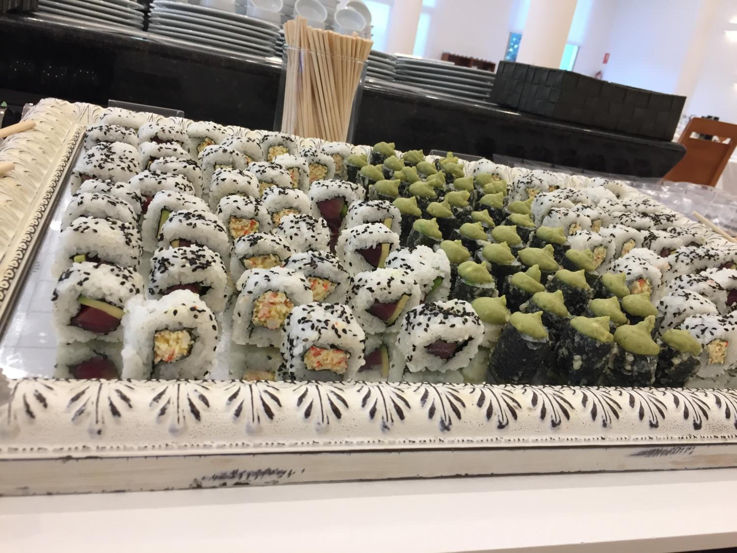 Un grand plateau rempli de différents types de sushis, disposés avec soin en rangées.