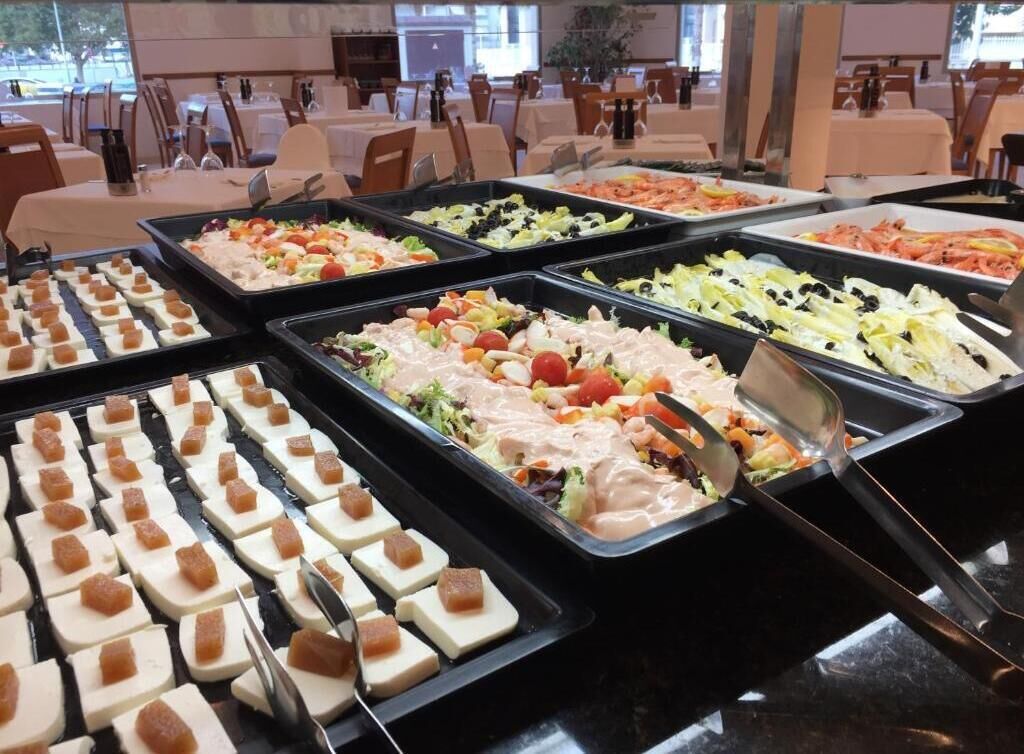 Un buffet proposant une variété de plats, notamment des salades, des viandes et des amuse-gueules.