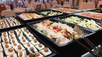 Un buffet proposant une variété de plats, notamment des salades, des viandes et des amuse-gueules.