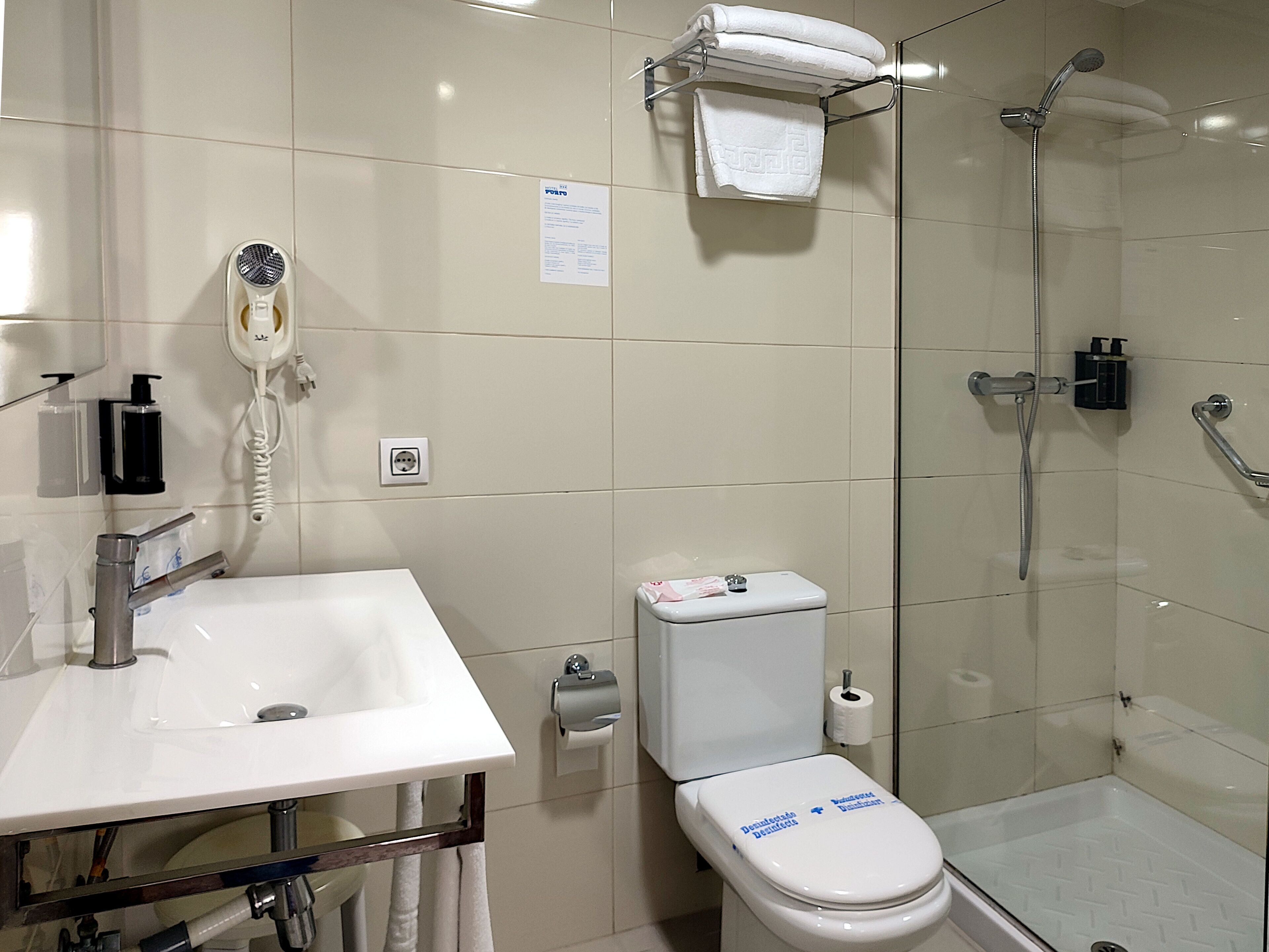 A modern bathroom with a sink, toilet, and glass-enclosed shower.