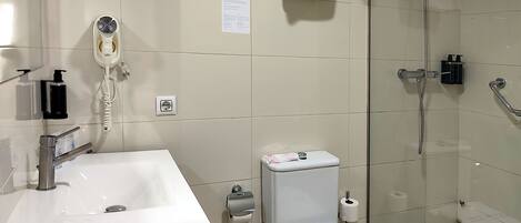 A modern bathroom with a sink, toilet, and glass-enclosed shower.