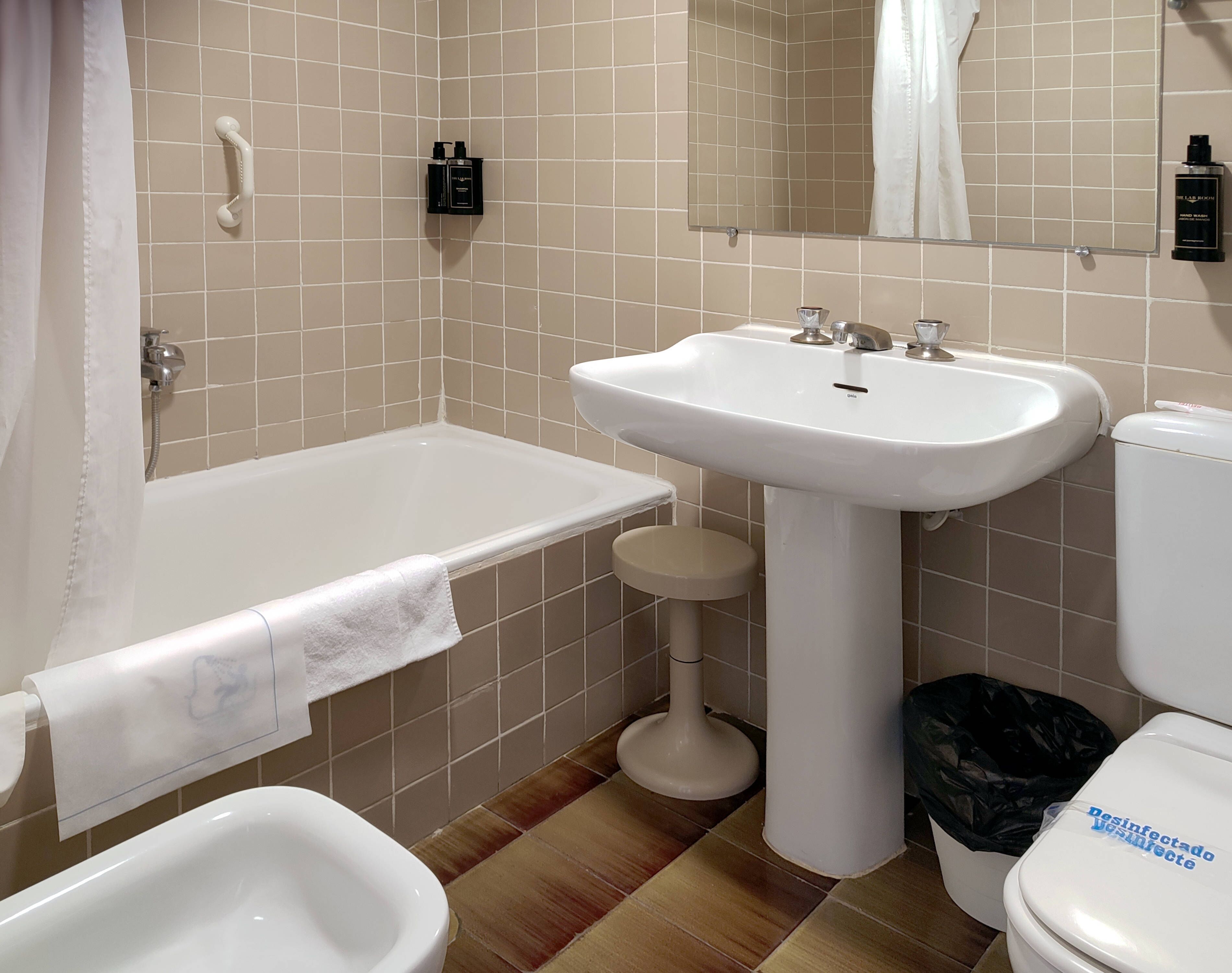 Une salle de bain équipée d’une baignoire, d’un lavabo, d’un bidet et de toilettes.