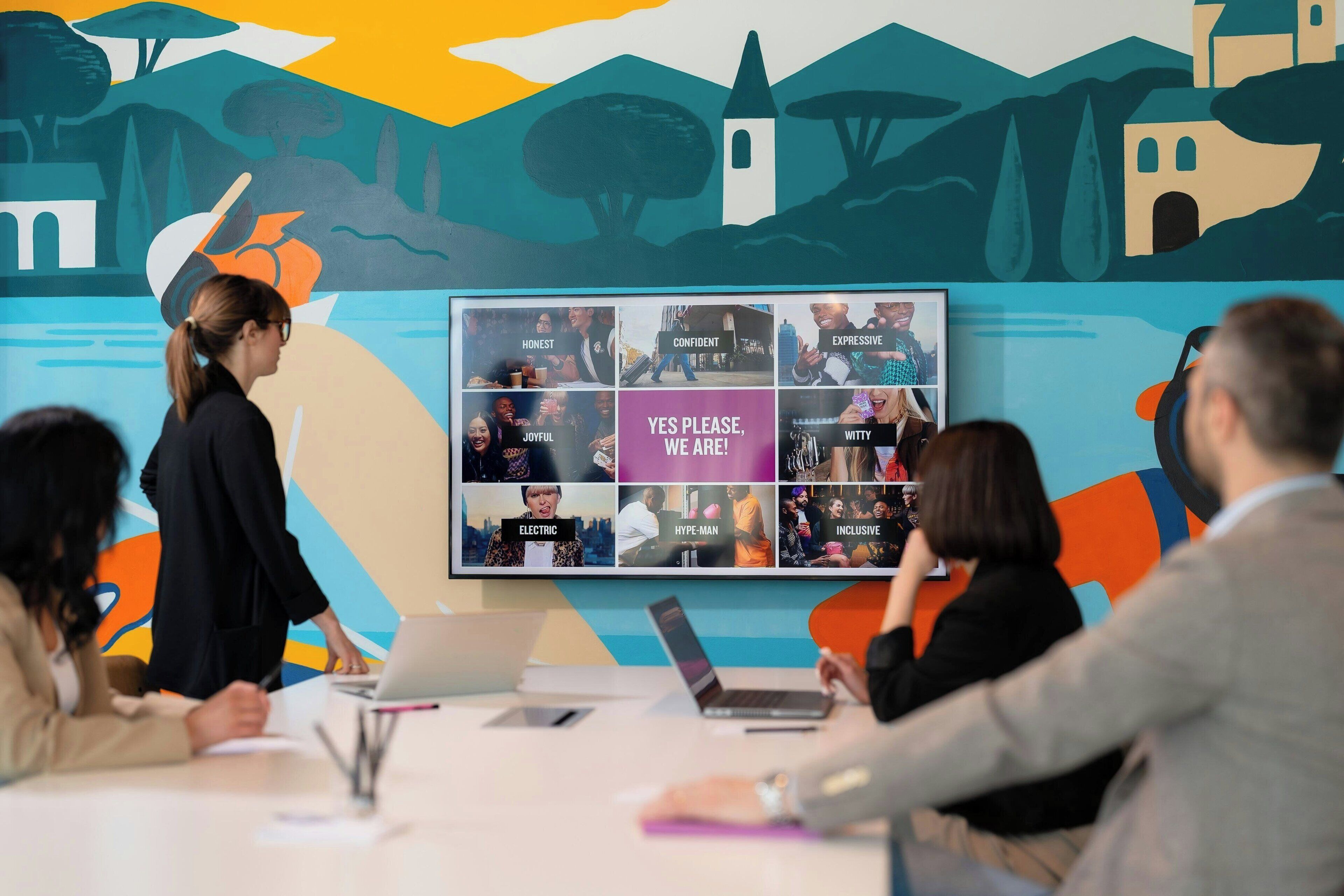 A conference room with a large display board featuring various team attributes.