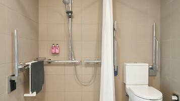 Ein modernes Badezimmer mit Dusche, Toilette und Handtuchhalter.