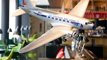 Ein Modellflugzeug schwebt in einem modernen Innenraum mit Büchern und Dekorationselementen.