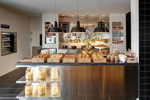 A buffet area with various food items and condiments.
