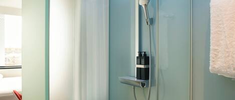 A modern shower with a handheld showerhead and a wall-mounted control panel.