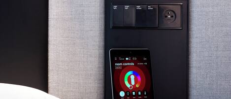 A modern control panel with a smartphone interface for room controls, including night and day lighting options.