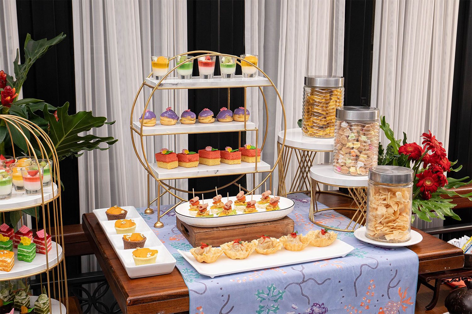 A buffet table with various food items and a dessert display.