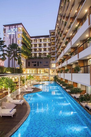 A hotel with a swimming pool, multiple balconies, and a well-lit facade. - THE 1O1 Yogyakarta Tugu (Yogyakarta)