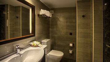 A modern bathroom with a large mirror, a sink, a toilet, and a shower area.