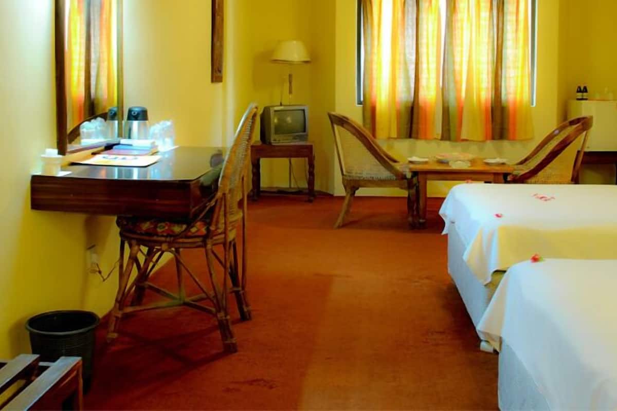 Ein Hotelzimmer mit Bett, Schreibtisch, Stuhl, Fernseher und Lampe.