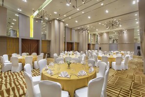 A banquet hall with round tables set for events, white chairs, and a patterned carpet. - Hilton Garden Inn Bali Ngurah Rai Airport (Tuban)