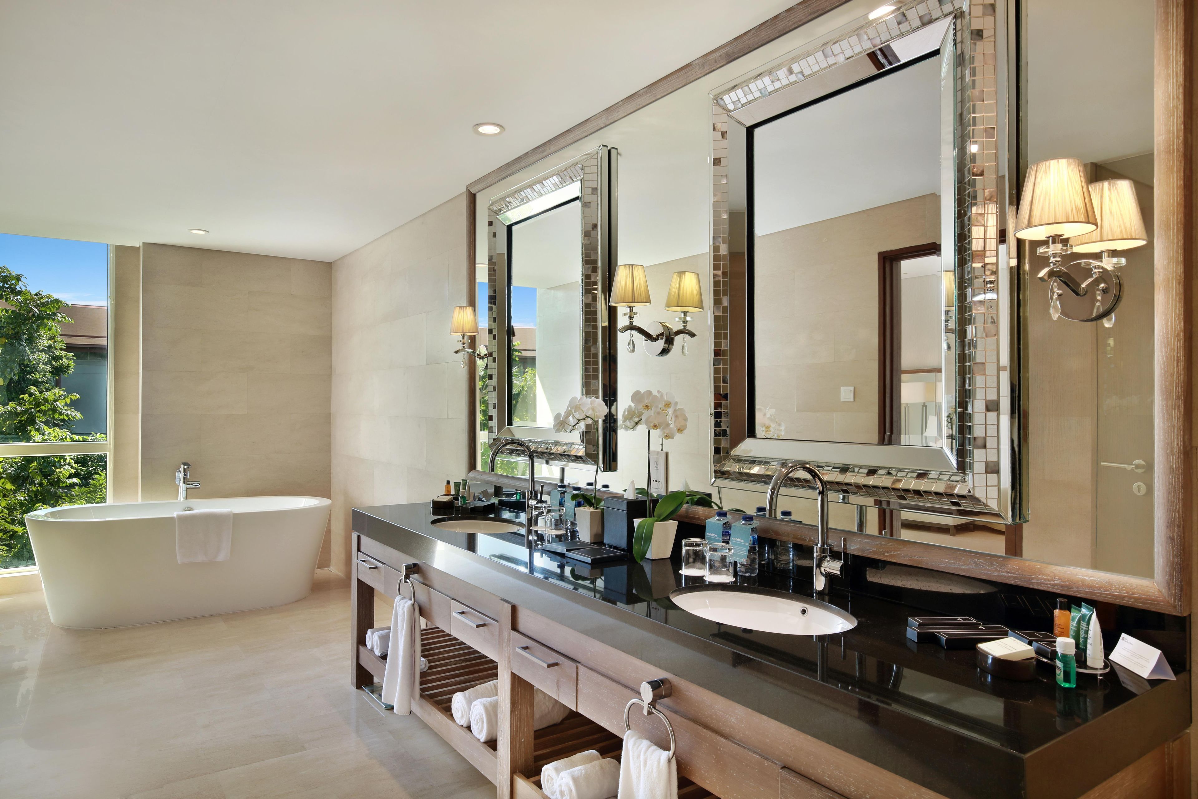 Un bagno moderno con una vasca freestanding, un ampio vanità con specchio e cabina doccia in vetro.