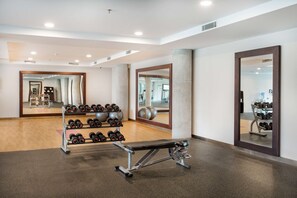 A gym with a bench, dumbbells, and exercise balls. - Hilton Garden Inn Bali Ngurah Rai Airport (Tuban)