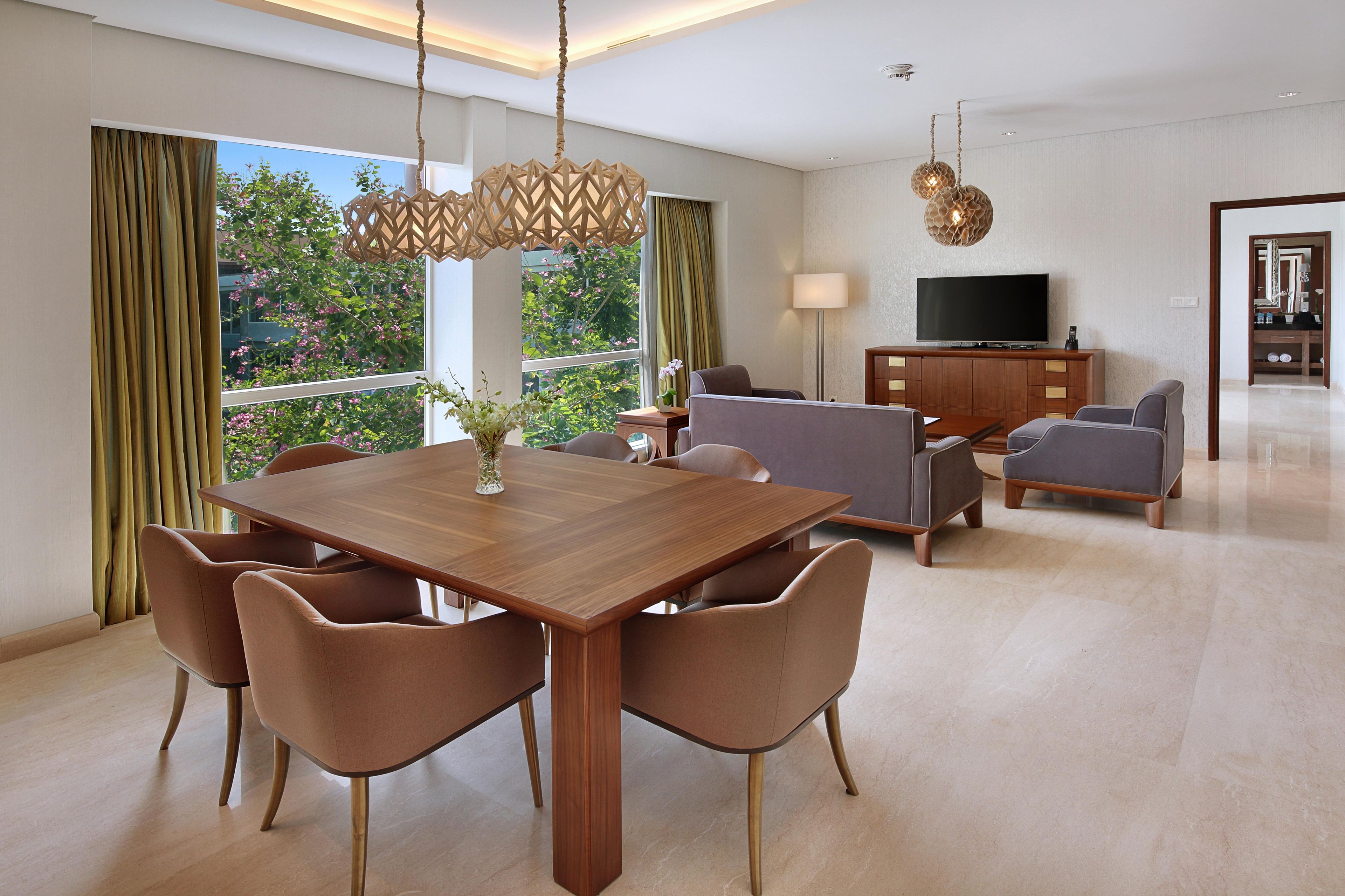 Una sala moderna con una mesa de comedor de madera, sofás y un televisor.