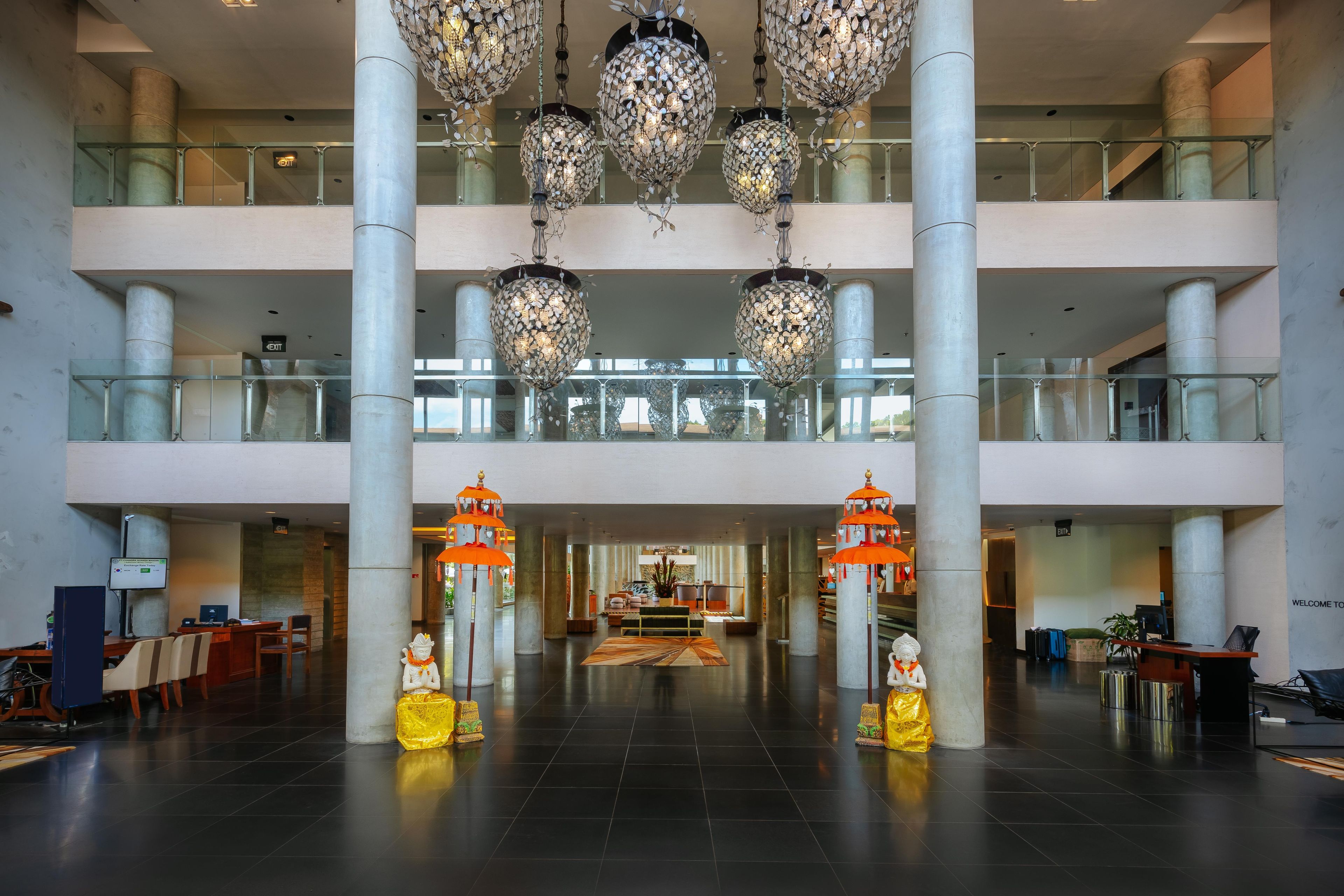A spacious lobby with multiple floors, large columns, and ornate chandeliers.