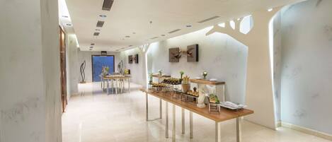 A spacious hotel corridor with a long reception desk, modern decor, and a clean, minimalist design.