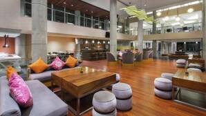 A spacious lobby with high ceilings, large windows, and a modern design. - Hilton Garden Inn Bali Ngurah Rai Airport (Tuban)