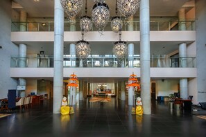 Un hall d’entrée spacieux avec un plafond haut, de nombreux étages et un comptoir d’accueil central.