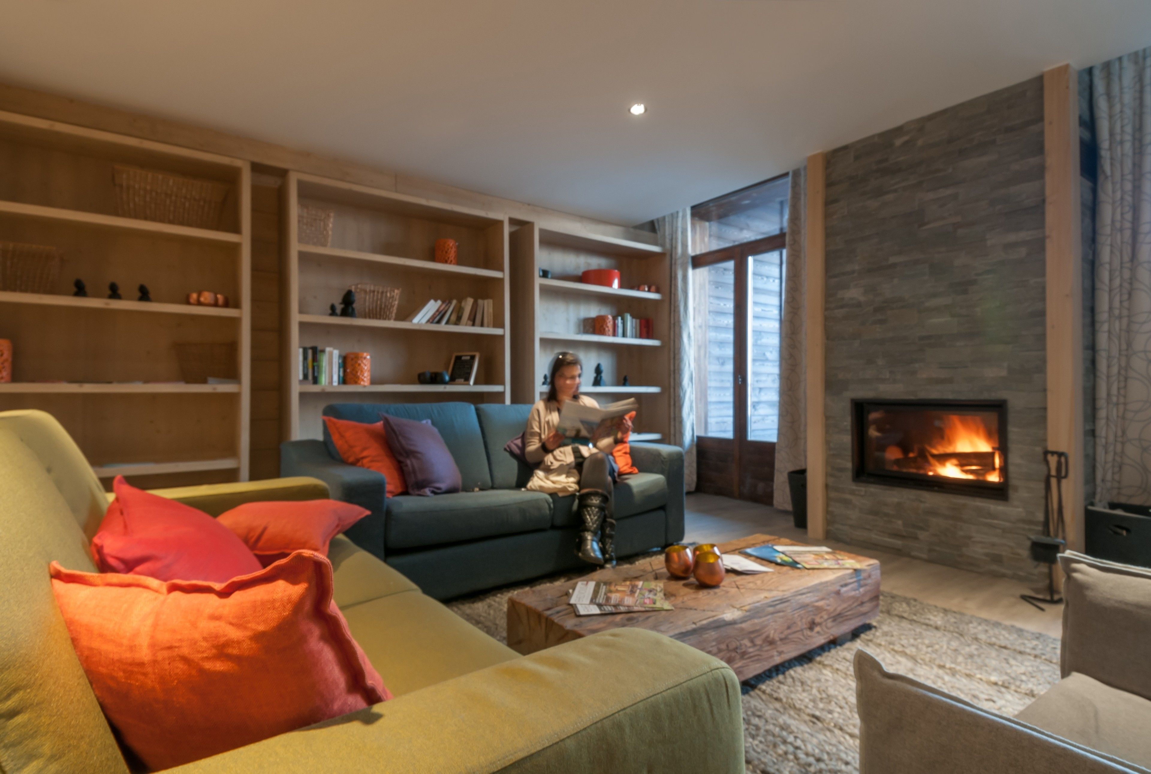 A modern living room with a sofa, coffee table, and bookshelves.